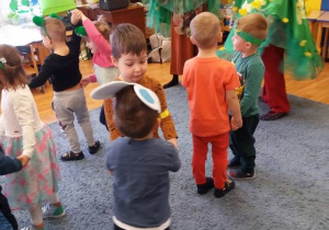 Dzieci w przebraniach tańczą w małych kółeczkach